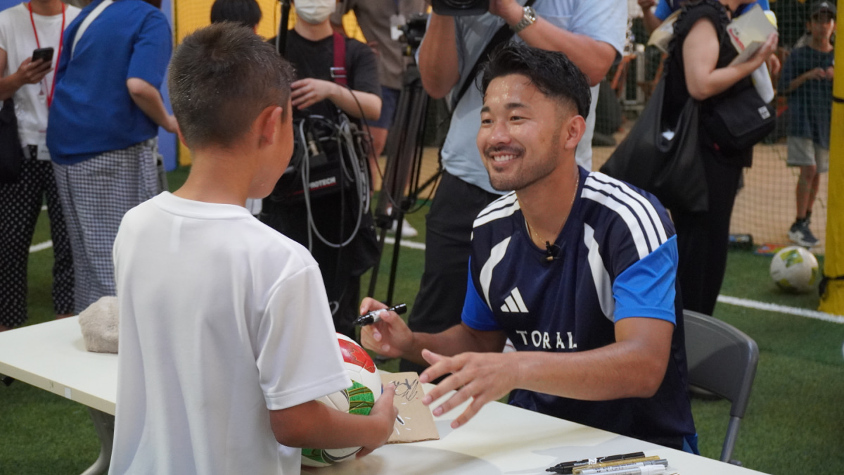 英語を交えたサッカー教室を行った菅原由勢はイベント終了後、サイン会を開き、参加者全員に笑顔で対応した